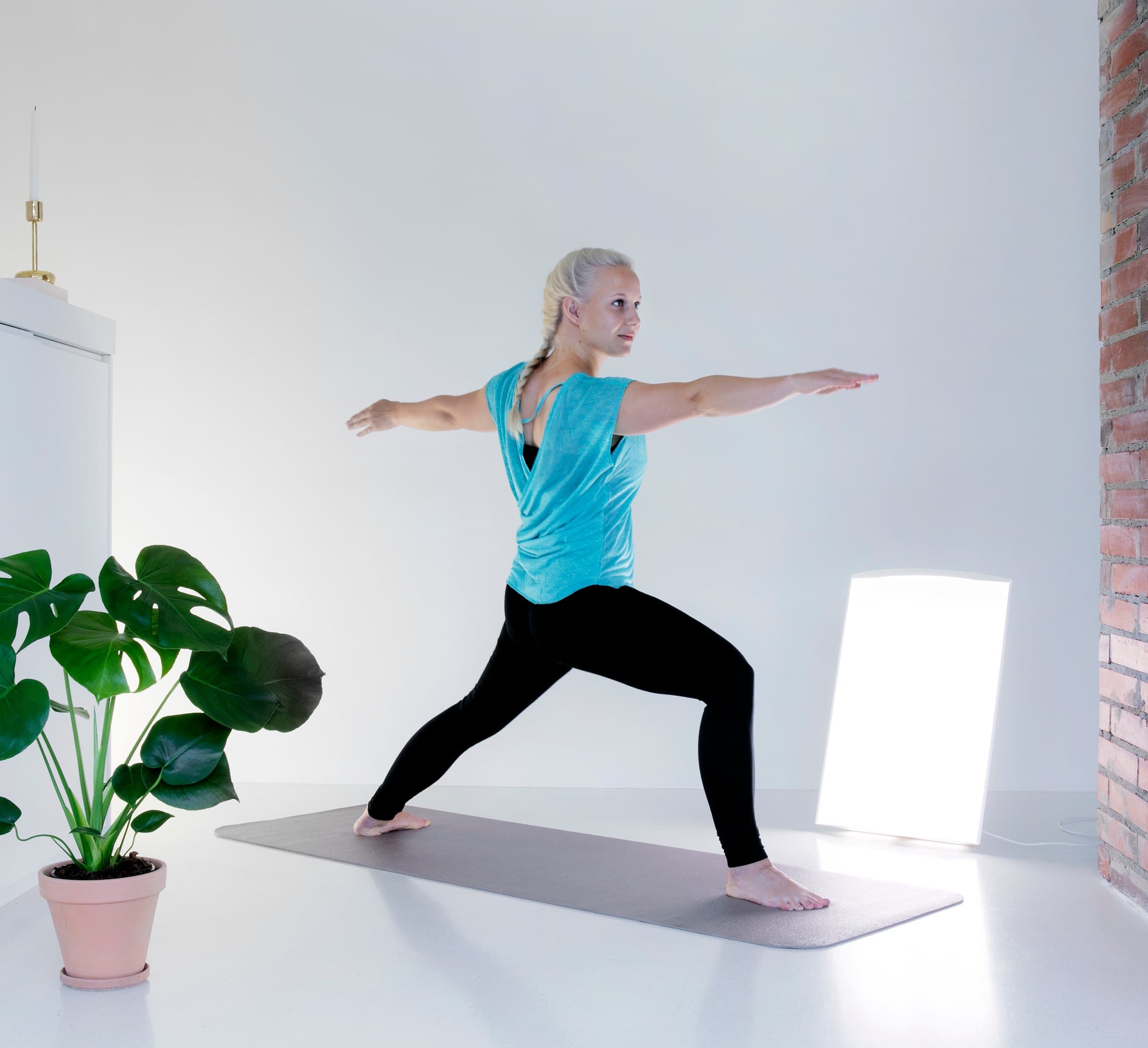 Frau macht Yoga vor der SAN Super Nova Dim in einem hellen Raum